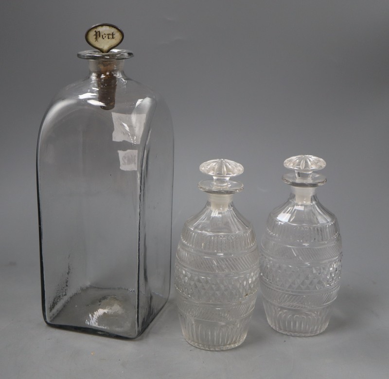 A tall early 19th century Dutch glass case decanter and a pair of cut glass barrel shaped spirit decanters